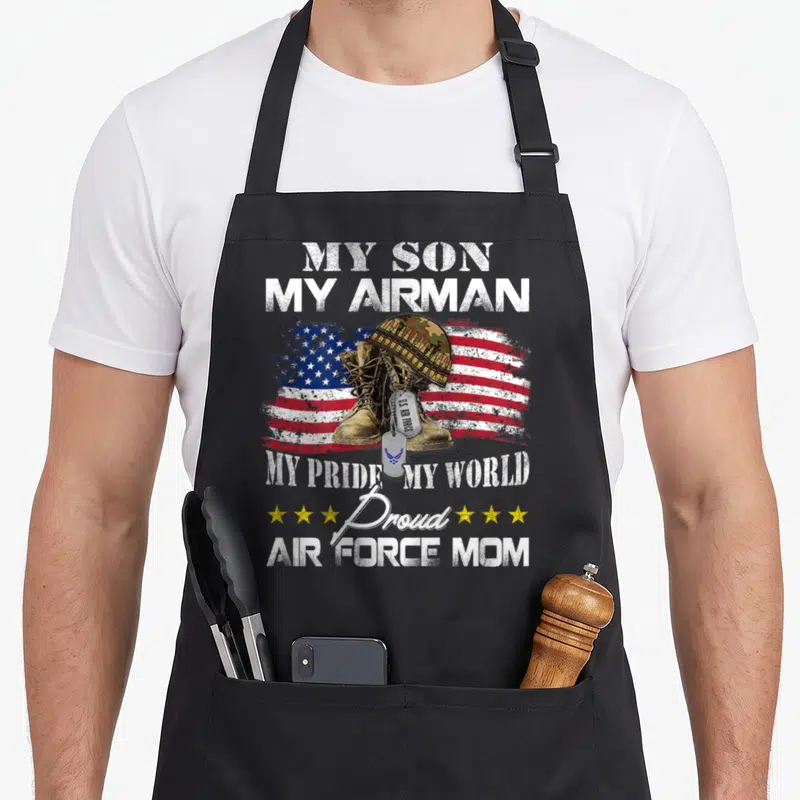 Graduation military apron - My Son My Airman text over boots helmet dog tags and distressed flag with yellow stars — shown on a black cotton canvas apron against a white background