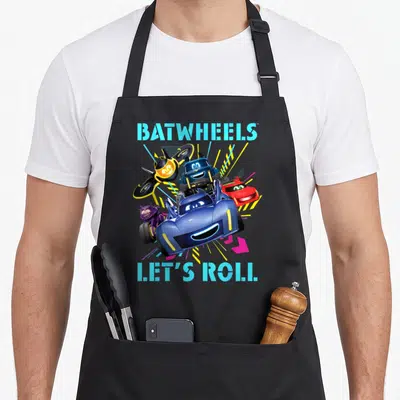 Batwheel girl birthday apron - Four smiling cartoon vehicles with blue text BATWHEELS and LET'S ROLL — shown on a black cotton canvas apron against a white background