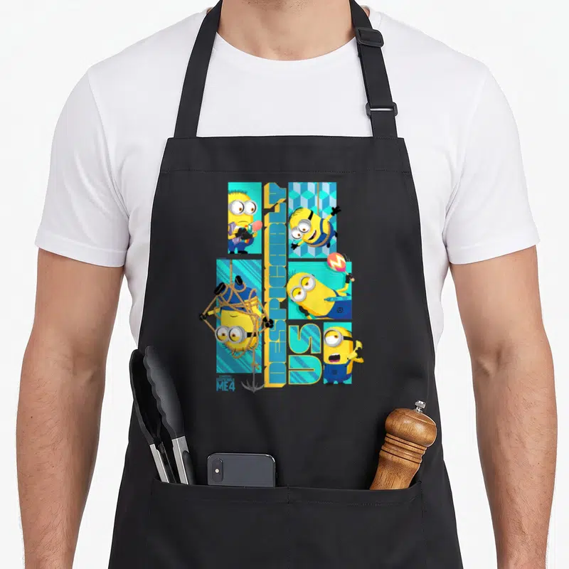 Despicable us aprons - Four Minions in poses around vertical Despicable Me 4 text — shown on a black cotton canvas apron against a white background