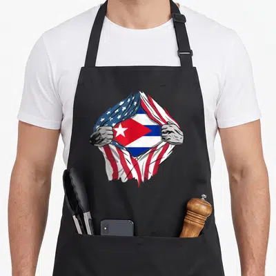 Blood american flag apron - Two grey hands rip USA flag to reveal Cuban flag in red white blue — shown on a black cotton canvas apron against a white background