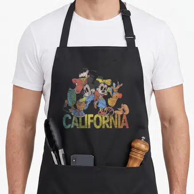 California friends cooking apron - Retro four-character cluster with red blue yellow green CALIFORNIA text — shown on a black cotton canvas apron against a white background
