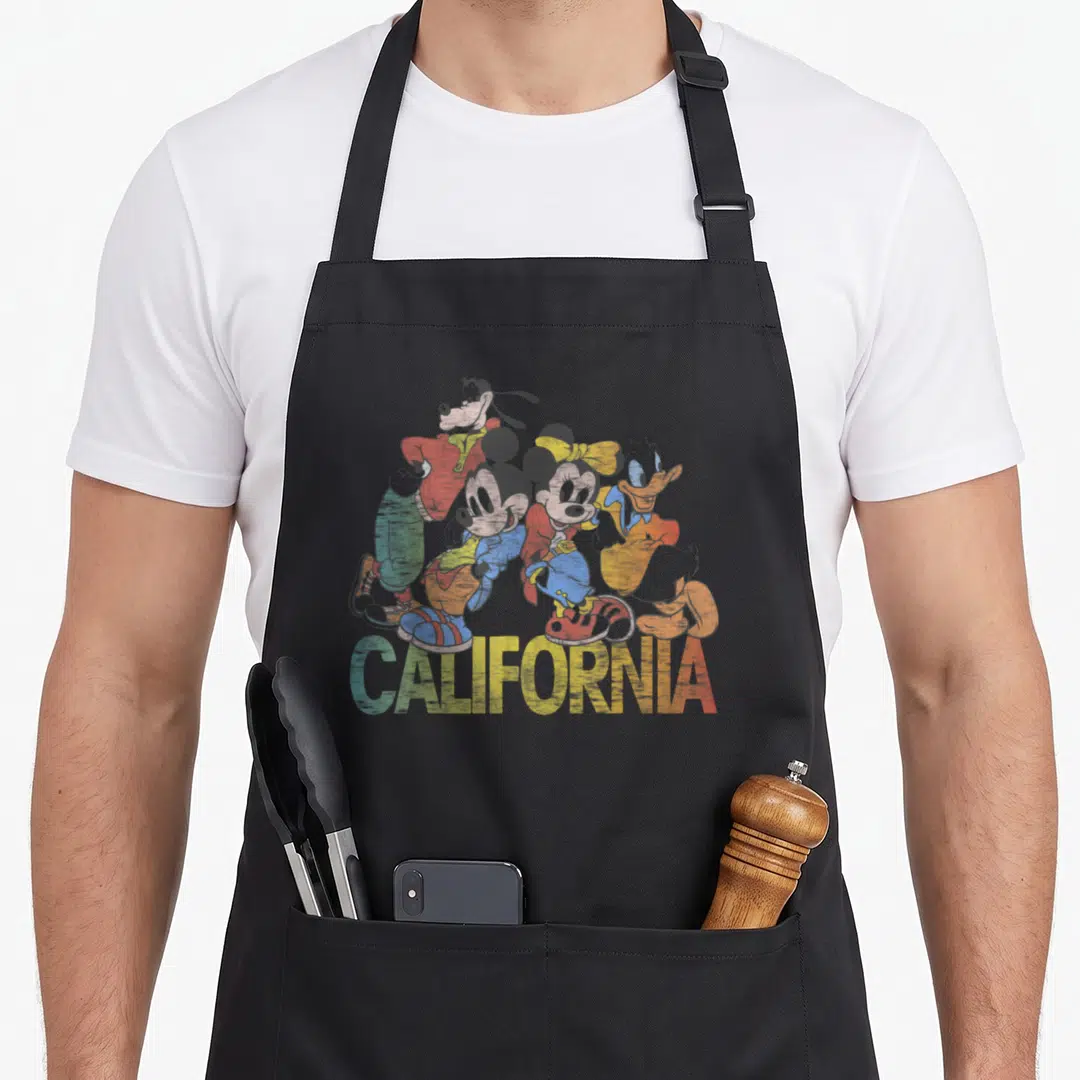 California friends cooking apron - Retro four-character cluster with red blue yellow green CALIFORNIA text — shown on a black cotton canvas apron against a white background