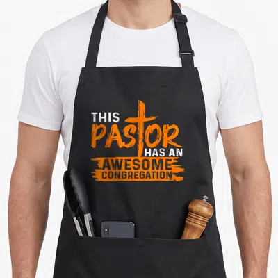 Appreciation christian apron - Orange cross overlapping PASTOR text with AWESOME CONGREGATION on brush strokes — shown on a black cotton canvas apron against a white background
