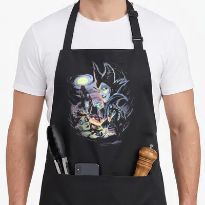 Painting beauty apron - Maleficent looms over reclining Aurora with castle and moon in purple blue yellow cartoon style — shown on a black cotton canvas apron against a white background