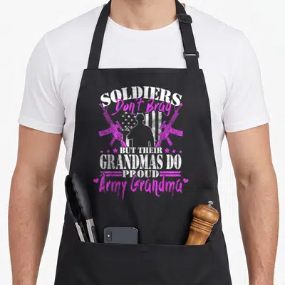 Brag grandma apron - Soldiers Don't Brag text with soldier silhouette, crossed rifles, and stars in white and pink — shown on a black cotton canvas apron against a white background