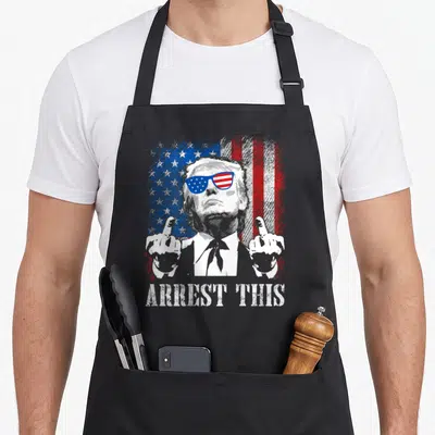 Arrest american flag apron - Distressed Trump portrait with middle finger gesture in front of US flag and ARREST THIS — shown on a black cotton canvas apron against a white background
