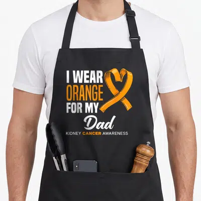 Support cancer kidney disease awareness apron - Stacked I Wear Orange For My Dad text with orange awareness ribbon — shown on a black cotton canvas apron against a white background