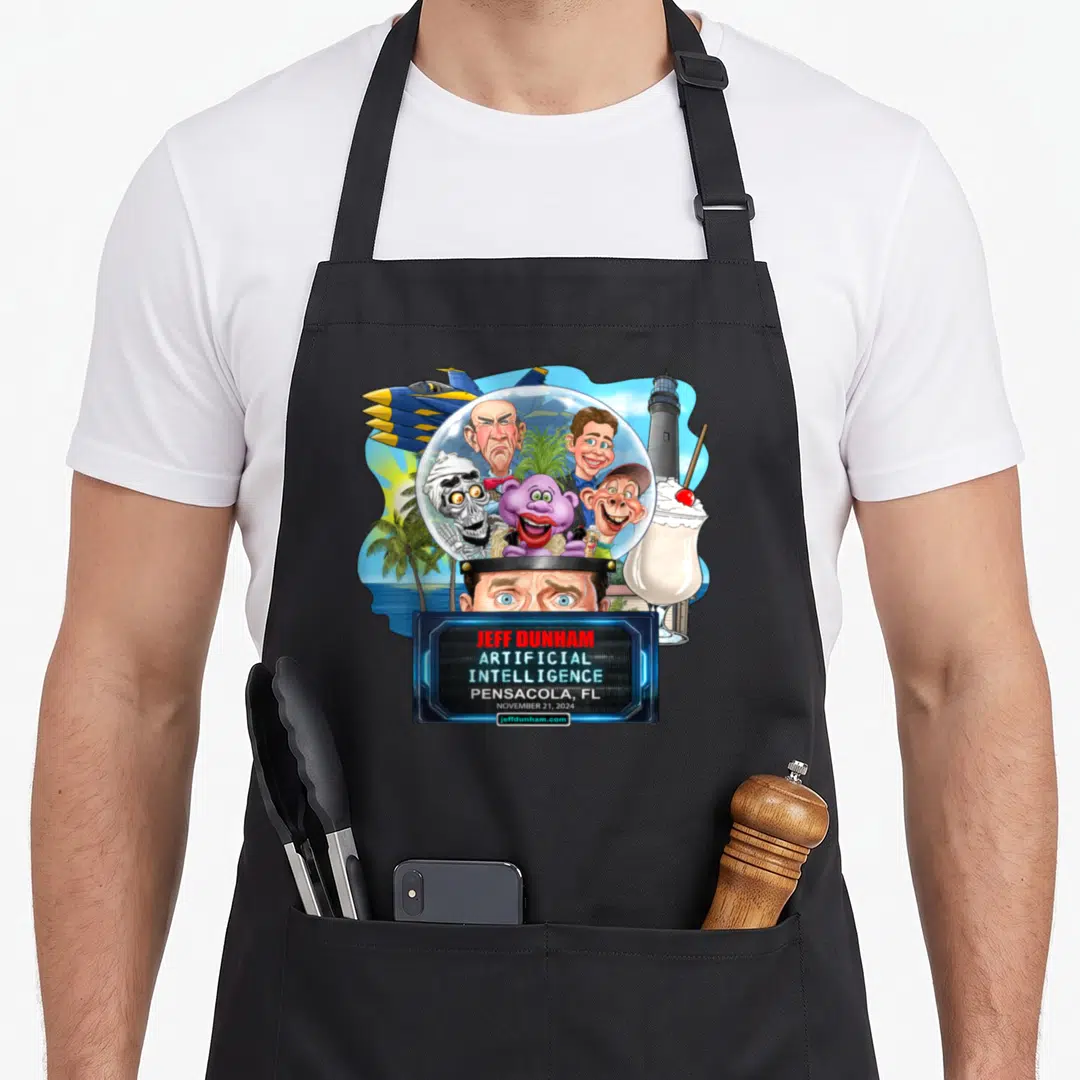 Jeff dunham pensacola apron - Jeff Dunham cartoon head with puppets in dome, lighthouse, jet, and text box showing — shown on a black cotton canvas apron against a white background