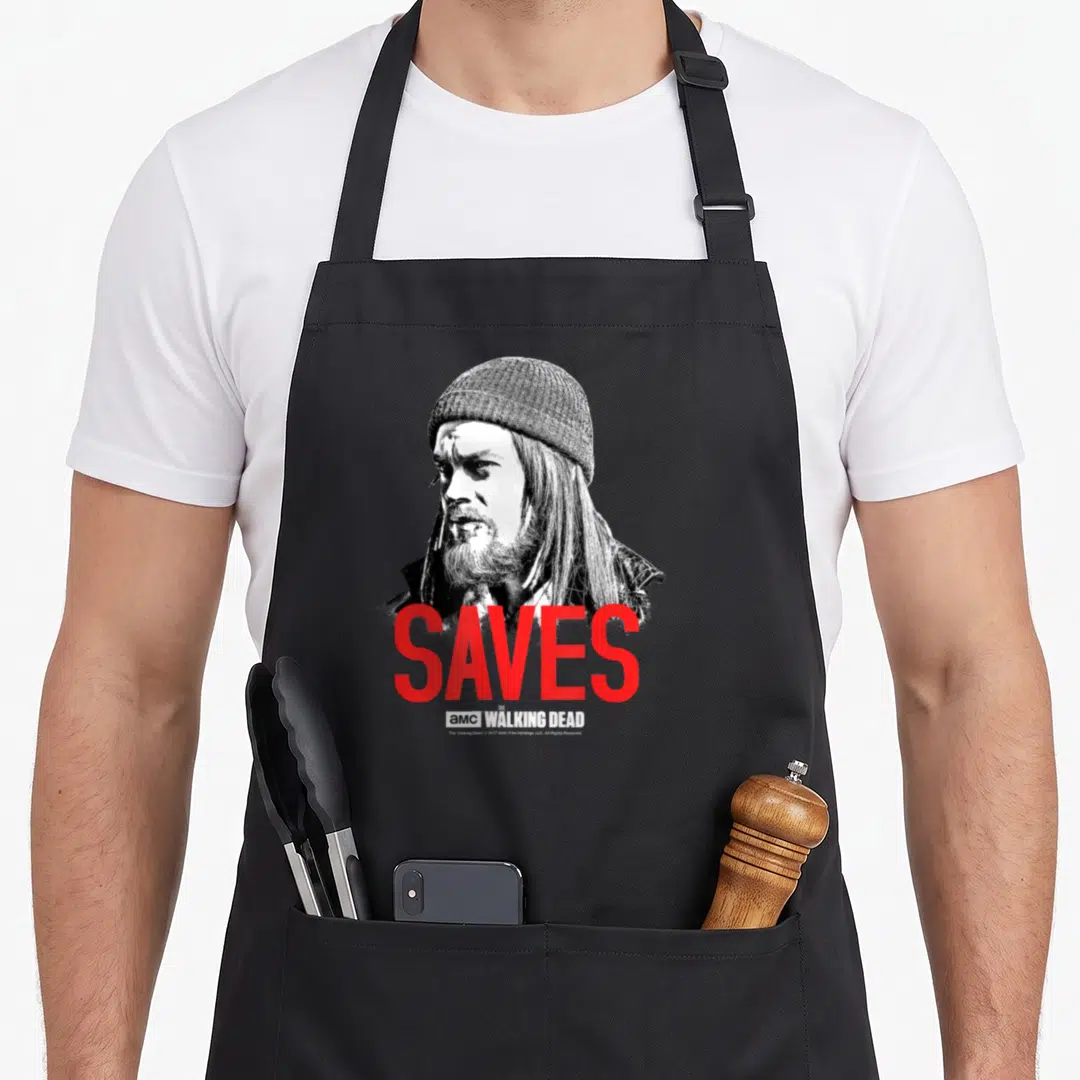 Twd fan gear apron - Black and white portrait of a man with red SAVES text and AMC logo below — shown on a black cotton canvas apron against a white background