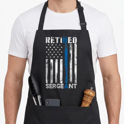 Retired sergeant american flag apron - Distressed American flag with thin blue line and text Retired Sergeant — shown on a black cotton canvas apron against a white background
