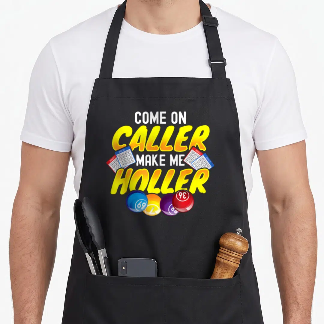 Lottery bingo aprons - Come On Caller Make Me Holler text with three bingo cards and four colored balls — shown on a black cotton canvas apron against a white background