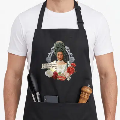 Bored queen apron - Woman portrait grey wig pearls red flowers gold crown gossip text torn strip — shown on a black cotton canvas apron against a white background