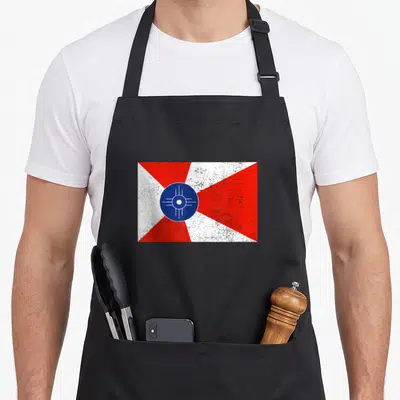 Distressed pride apron - Red white and blue distressed flag with central blue circle and radiating triangles — shown on a black cotton canvas apron against a white background