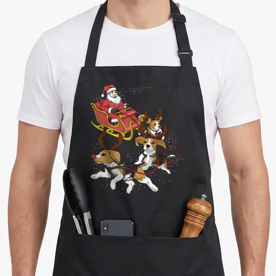 Christmas beagle apron - Santa in red sleigh pulled by three antlered beagles with white stars — shown on a black cotton canvas apron against a white background