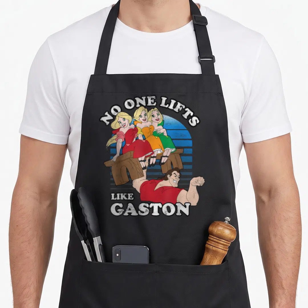 Lift galveston apron - Gaston lifting bench with three women under No One Lifts Like Gaston text — shown on a black cotton canvas apron against a white background