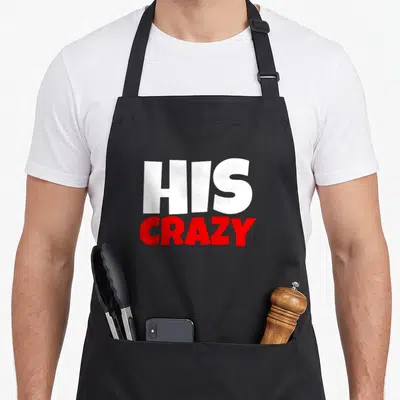 Weirdo his couple apron - Stacked white HIS and red CRAZY typography on black fabric — shown on a black cotton canvas apron against a white background