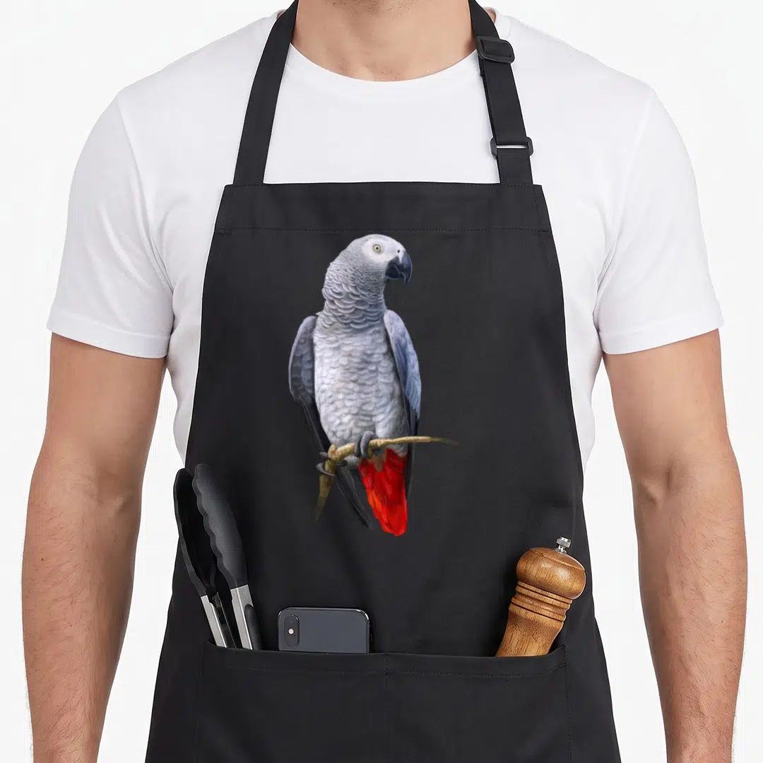 Beautiful african aprons - Realistic grey parrot with red tail perched on brown branch — shown on a black cotton canvas apron against a white background