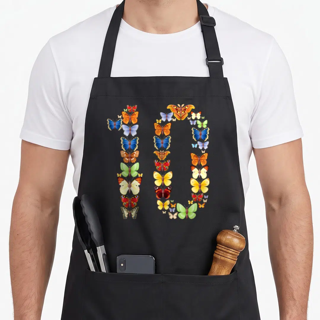 10th birthday butterfly aprons - Realistic blue orange yellow green red butterflies arranged to form the number 10 — shown on a black cotton canvas apron against a white background