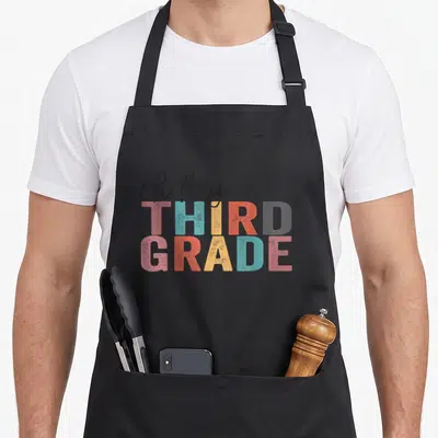 Hey third teacher apron - Oh Hey Third Grade colorful stacked block lettering in pink blue yellow orange grey and black — shown on a black cotton canvas apron against a white background