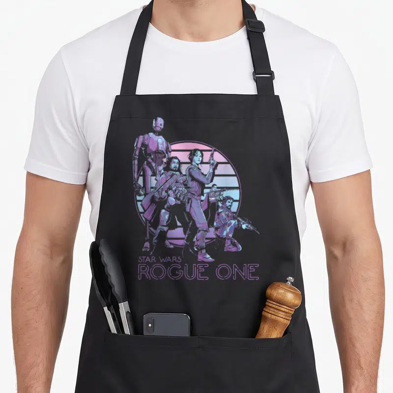 Rogue roguelike apron - Retro purple and pink Star Wars Rogue One character group before striped sun with centered — shown on a black cotton canvas apron against a white background