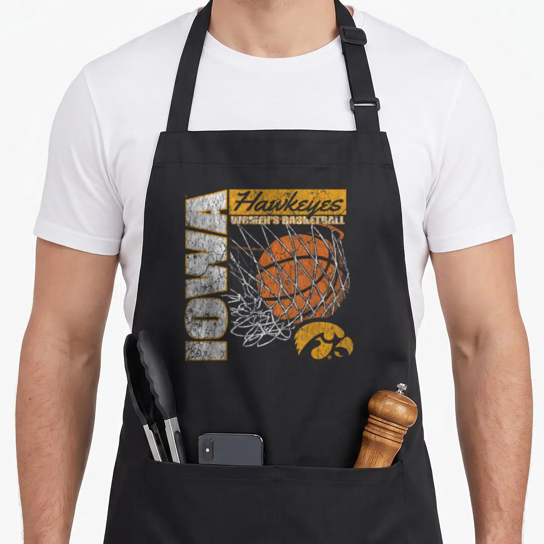 Funny iowa 90s apron - Vertical IOWA text, orange basketball in net, Hawkeyes script, and logo in distressed white — shown on a black cotton canvas apron against a white background