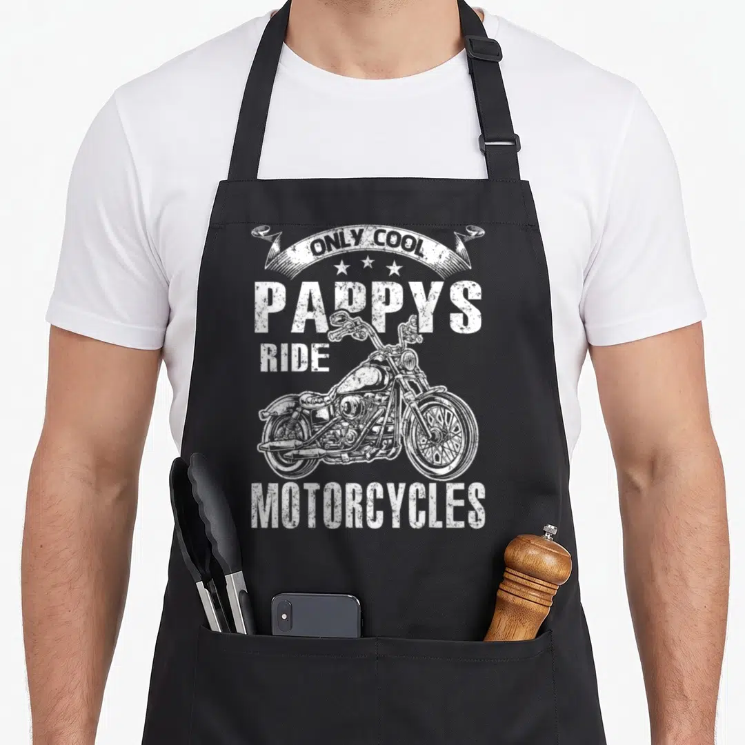 Pappy motorcycle apron - White distressed text Only Cool Pappys Ride Motorcycles above a motorcycle illustration — shown on a black cotton canvas apron against a white background
