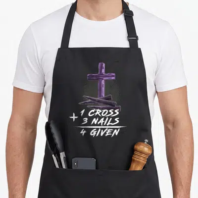 Three cross apron - Purple cross behind three nails with white stacked text reading 1 CROSS 3 NAILS 4 GIVEN — shown on a black cotton canvas apron against a white background