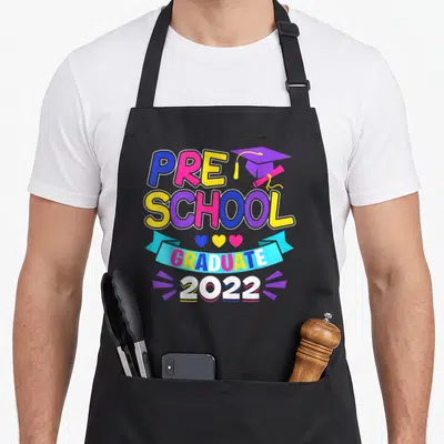 Graduate preschool apron - Stacked PRE SCHOOL GRADUATE 2022 text with cap, diploma, three hearts, and ribbon in blue — shown on a black cotton canvas apron against a white background