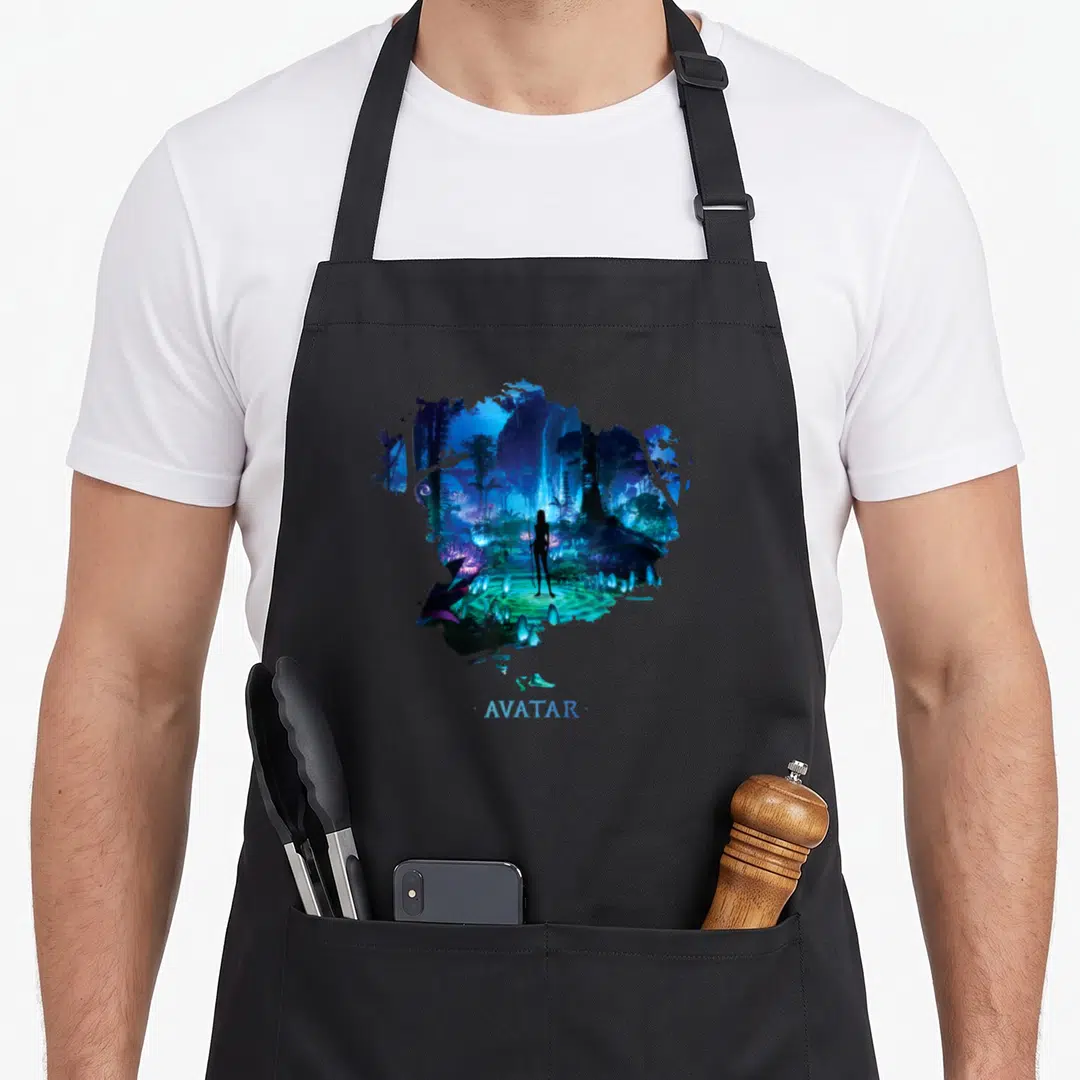 Avatar night apron - Na'vi woman silhouette in blue purple jungle with AVATAR text below splatter shape — shown on a black cotton canvas apron against a white background