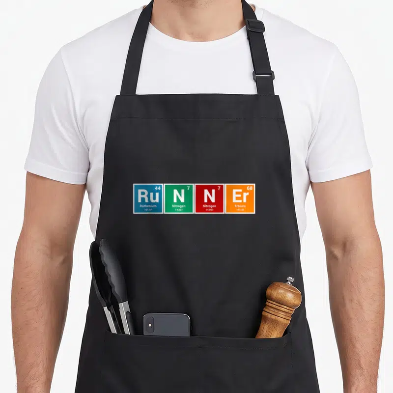 Runner table apron - Four colored squares spelling RUNNER with periodic table data including Ruthenium and Erbium — shown on a black cotton canvas apron against a white background