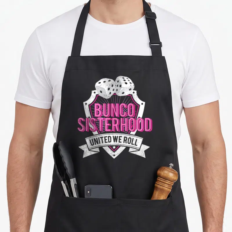 Bunco game aprons - Two white dice above pink shield reading Bunco Sisterhood United We Roll — shown on a black cotton canvas apron against a white background