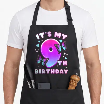 9th butterfly aprons - Number 9 with butterflies and It's My 9th Birthday text in purple and blue — shown on a black cotton canvas apron against a white background