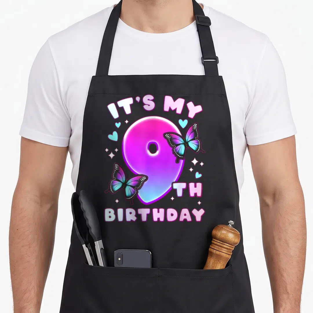 9th butterfly aprons - Number 9 with butterflies and It's My 9th Birthday text in purple and blue — shown on a black cotton canvas apron against a white background