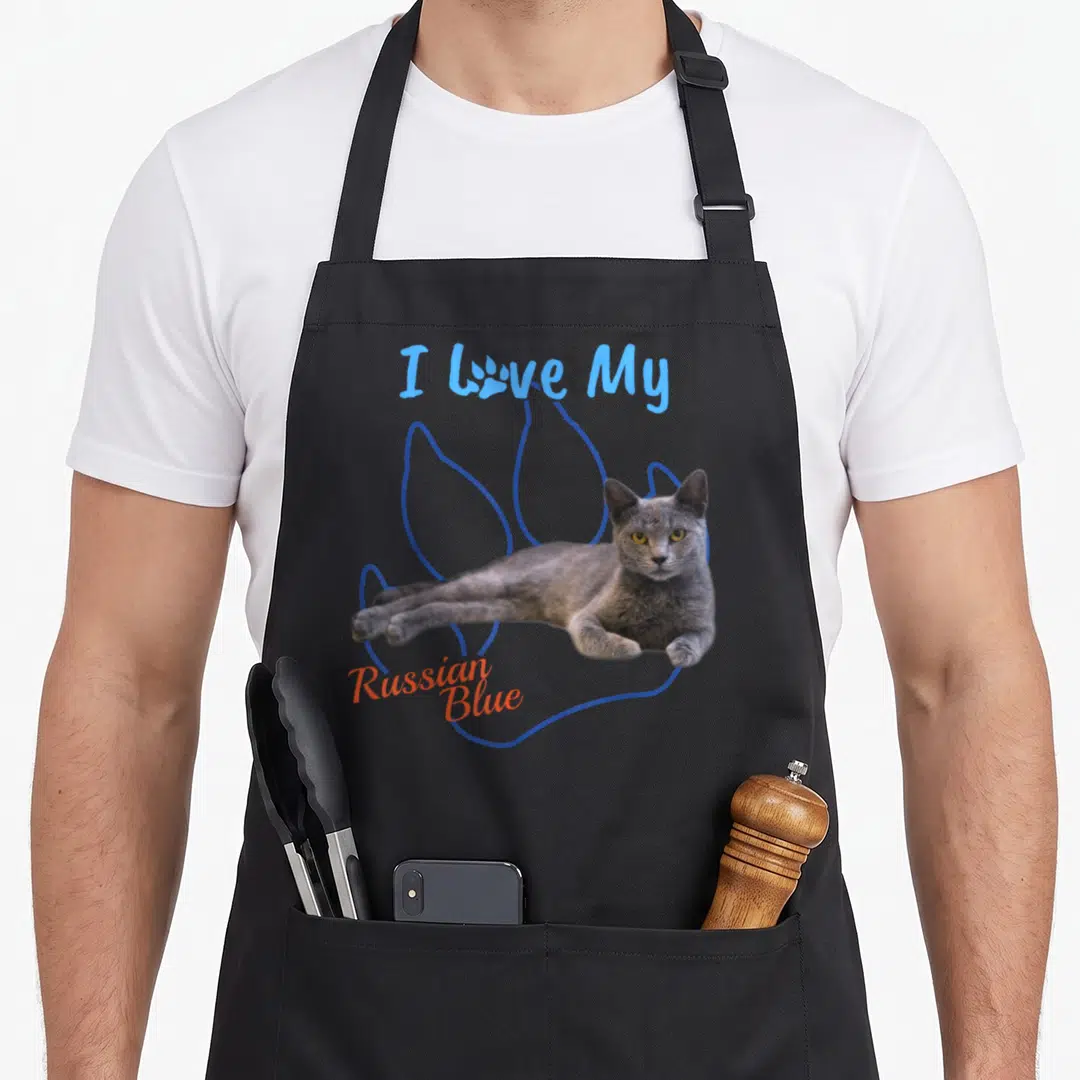 Paw russian aprons - I Love My Russian Blue text with grey cat photo on blue paw print outline — shown on a black cotton canvas apron against a white background