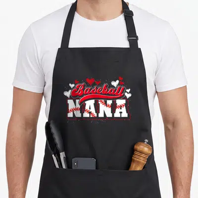 Nana grandma apron - Baseball NANA text with red stitching in letters and scattered red and white hearts — shown on a black cotton canvas apron against a white background
