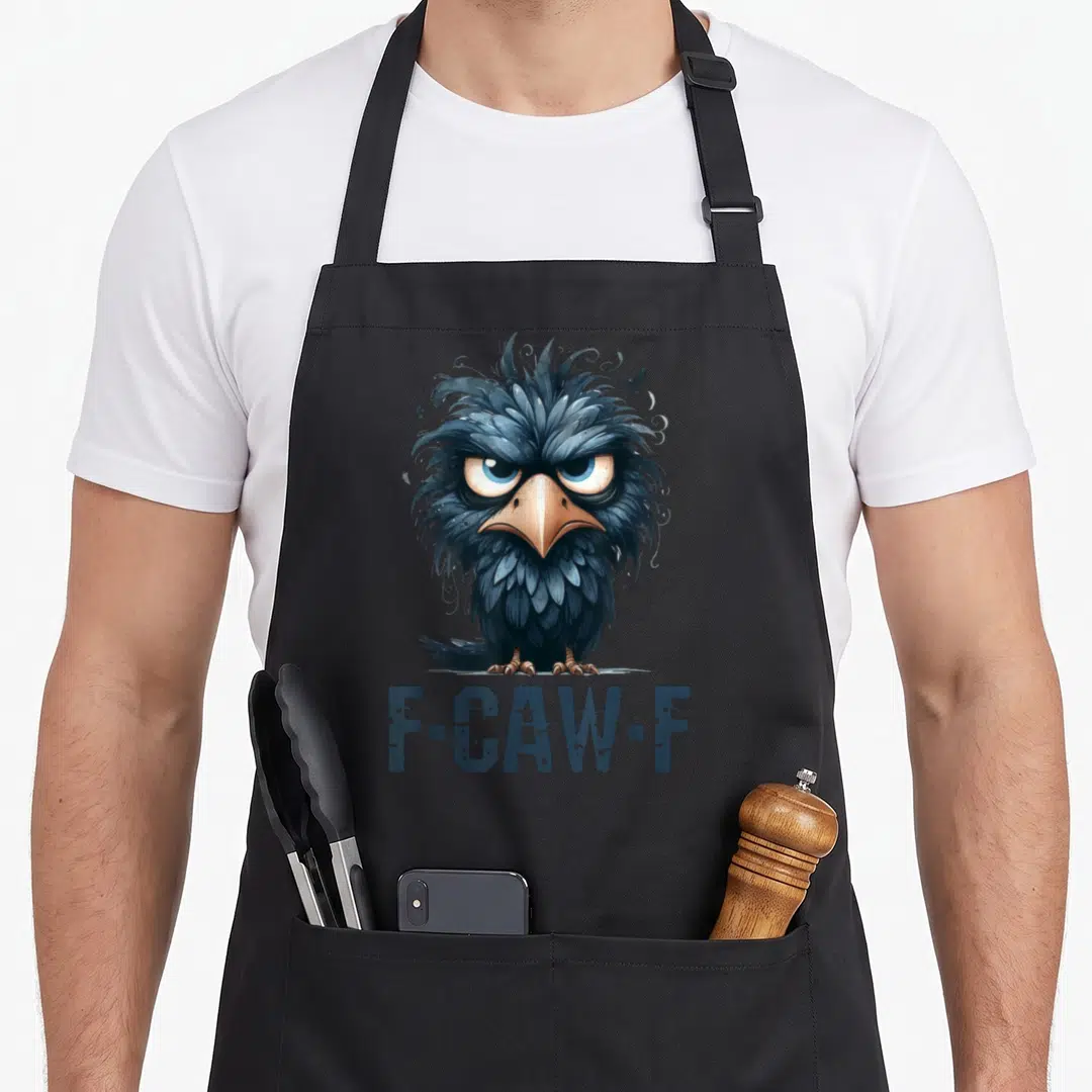 Caw crow bird aprons - Grumpy cartoon crow face above F-Caw-F text in dark blue and black with two small flying birds — shown on a black cotton canvas apron against a white background
