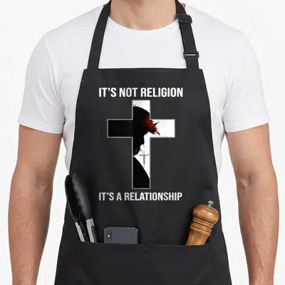 Religion personal apron - Cross with Jesus profile red crown of thorns white text on black — shown on a black cotton canvas apron against a white background