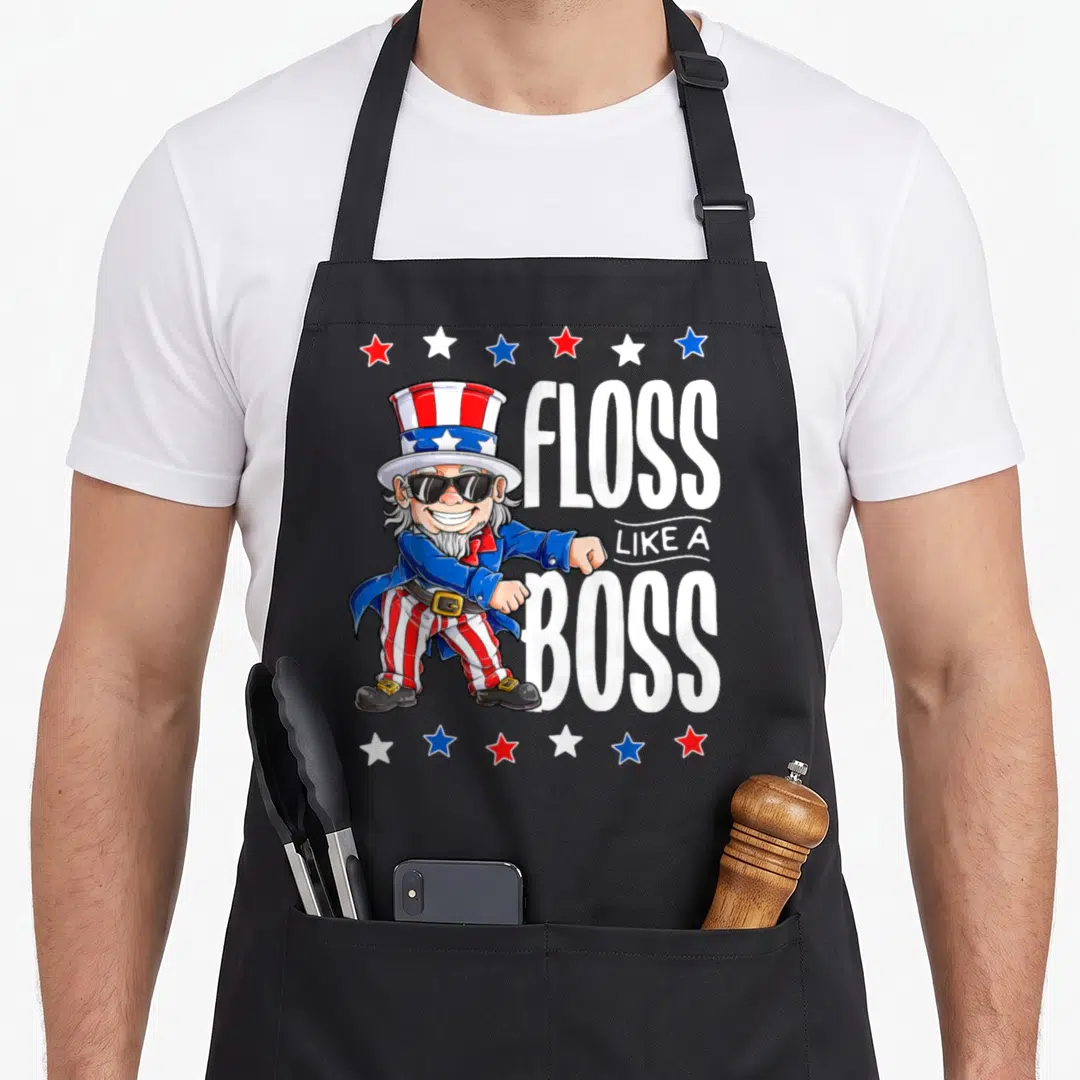 4th boss apron - Uncle Sam cartoon flossing next to FLOSS LIKE A BOSS text framed by rows of red, white, and blue stars — shown on a black cotton canvas apron against a white background