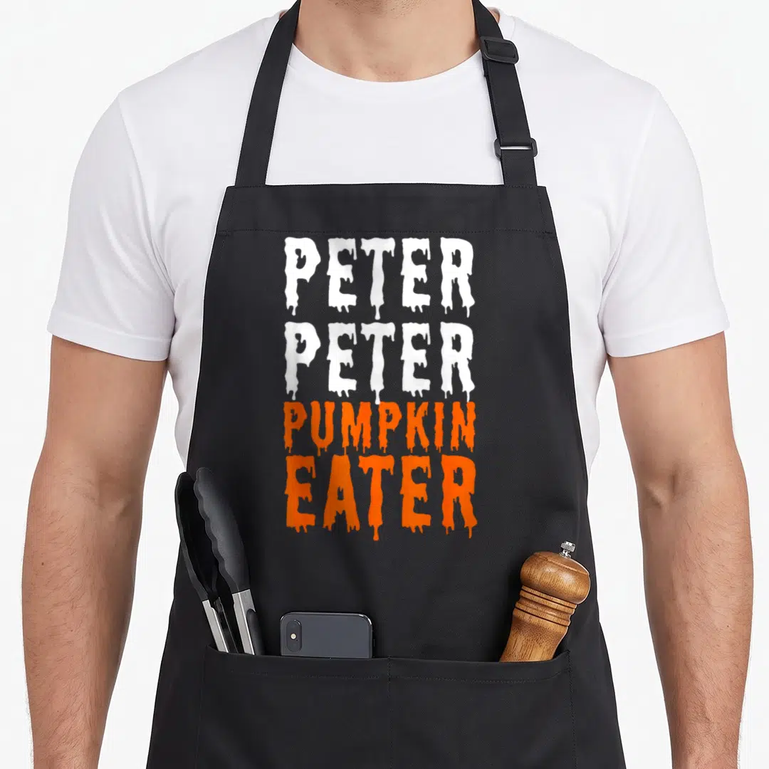 Eater halloween apron - Dripping white and orange text reading Peter Peter Pumpkin Eater in four stacked lines — shown on a black cotton canvas apron against a white background