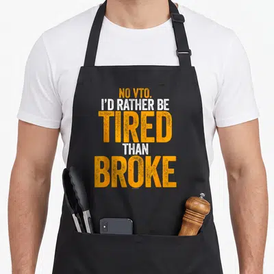 Vto swagazon apron - Orange and white text reading NO VTO I'D RATHER BE TIRED THAN BROKE stacked vertically — shown on a black cotton canvas apron against a white background