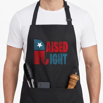 Right elephant print apron - Raised Right text with stylized flag R in red blue white distressed style — shown on a black cotton canvas apron against a white background