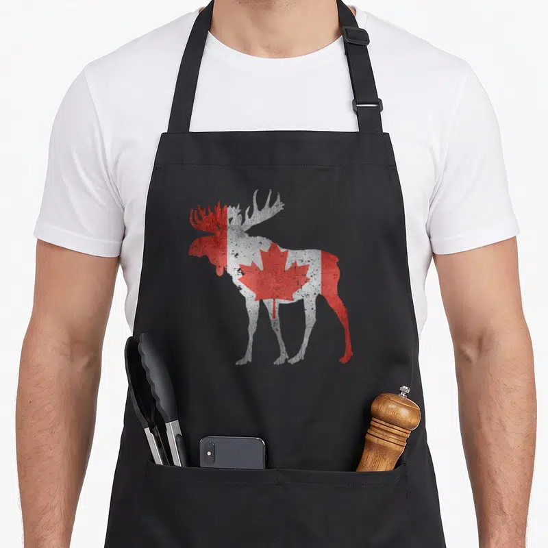 Animal pride apron - Moose silhouette filled with red and white Canadian flag pattern in distressed style — shown on a black cotton canvas apron against a white background