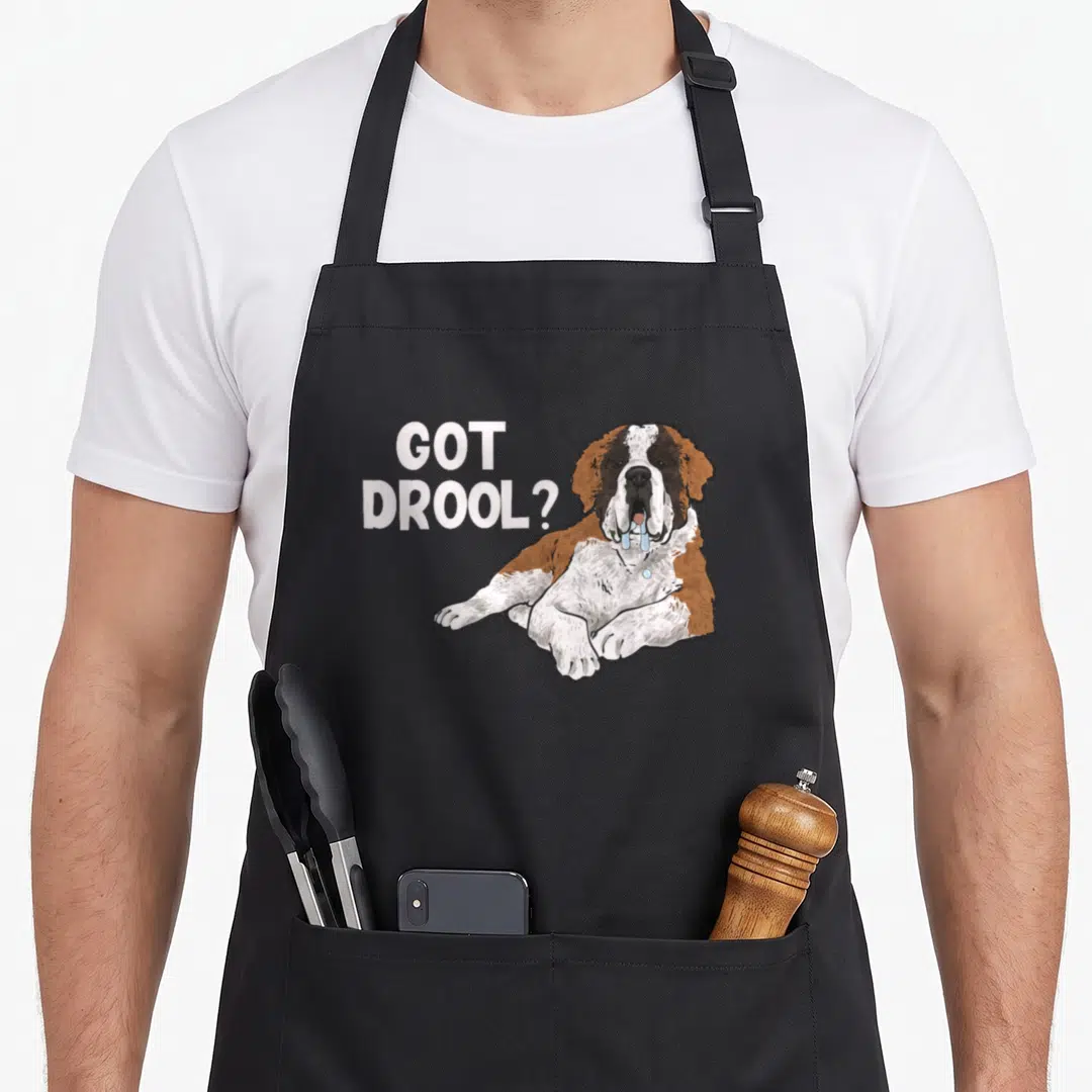 Drool dog apron - Cartoon Saint Bernard with blue drool and GOT DROOL text — shown on a black cotton canvas apron against a white background