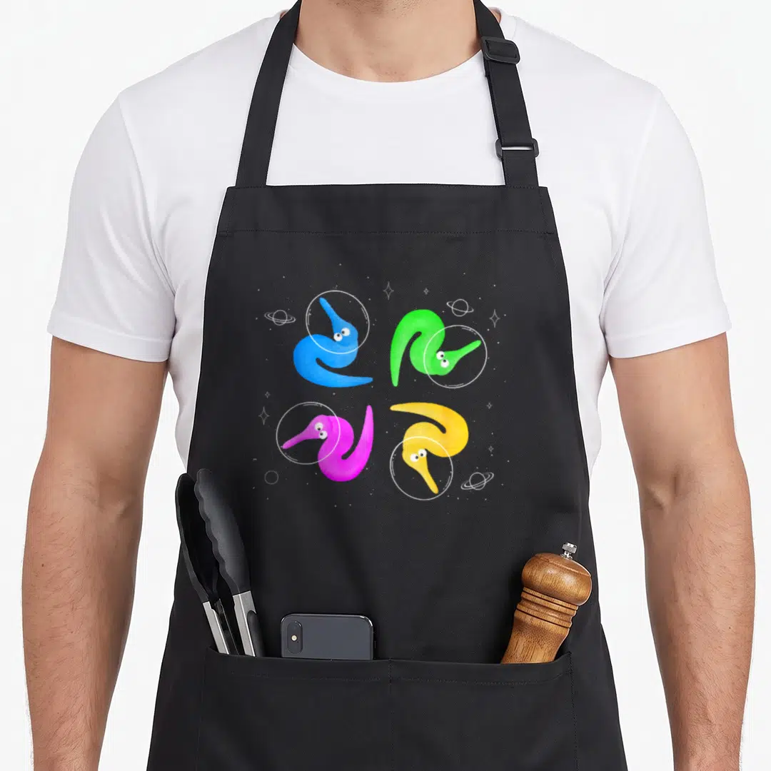String worm apron - Four colorful worms in white circles surrounded by space dots and planets — shown on a black cotton canvas apron against a white background