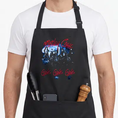 Tracklist e.a apron - Red script Motley Crue and Girls Girls Girls text around blue band photo with motorcycles — shown on a black cotton canvas apron against a white background