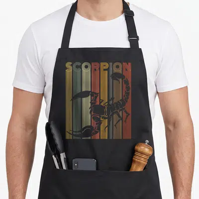 Cool scorpion apron - Retro SCORPION text in yellow orange red grey stripes with grey scorpion silhouette overlay — shown on a black cotton canvas apron against a white background