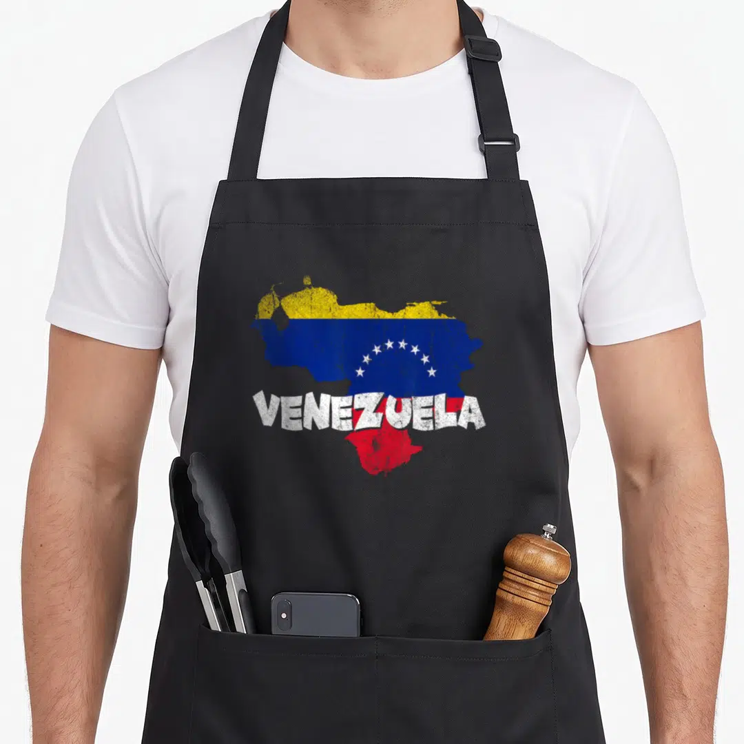 Caracas pride apron - Distressed map of Venezuela filled with yellow blue red flag colors and white text — shown on a black cotton canvas apron against a white background