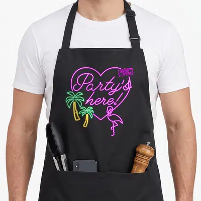 Mtv shore apron - Neon pink heart with Party's here text, two palm trees, and a flamingo in line art — shown on a black cotton canvas apron against a white background