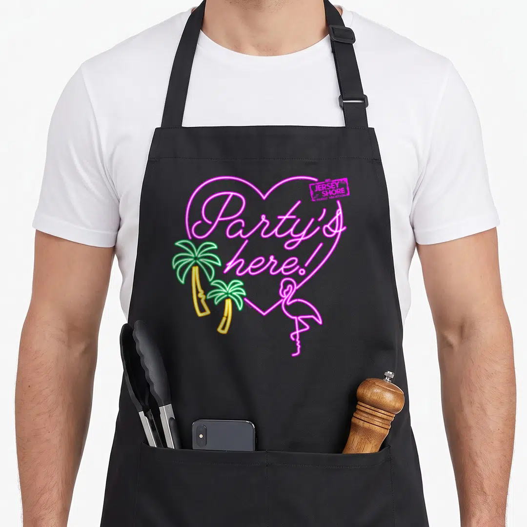 Mtv shore apron - Neon pink heart with Party's here text, two palm trees, and a flamingo in line art — shown on a black cotton canvas apron against a white background
