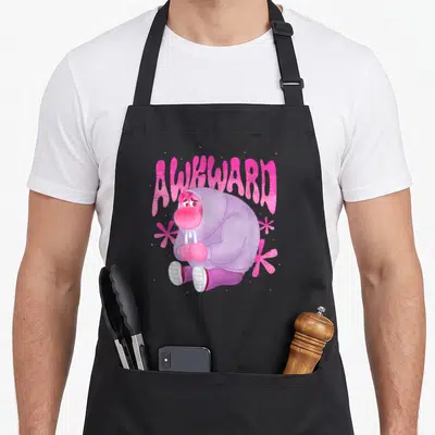 Embarrassment awkward apron - Pink arched AWKWARD text over purple character with three flowers — shown on a black cotton canvas apron against a white background